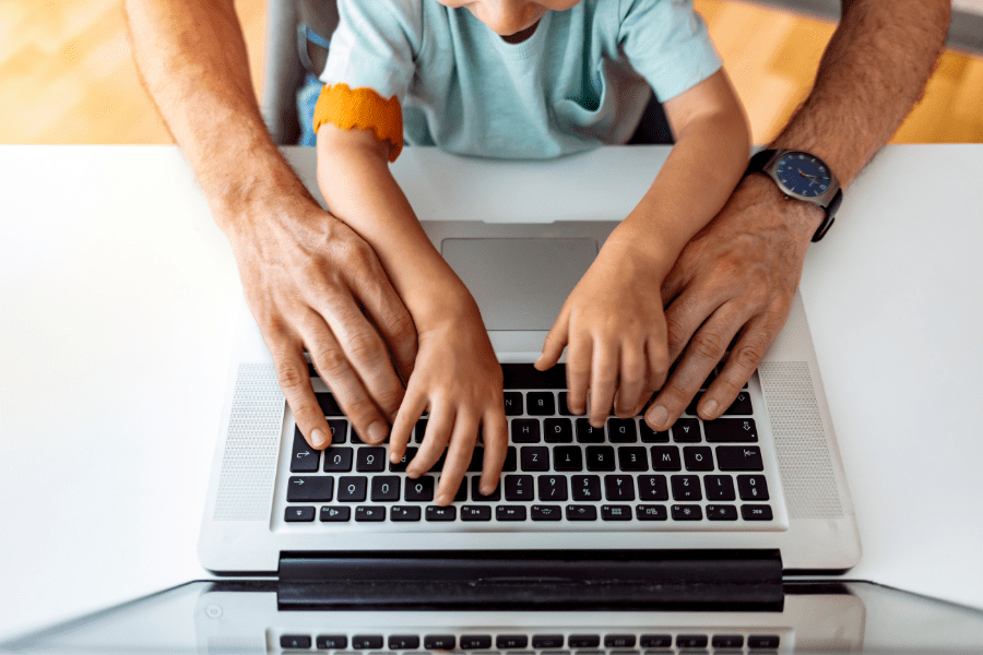 a parent working on a laptop with child at home