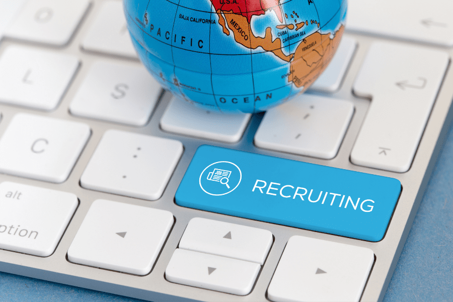 a globe placed on a keyboard with a recruiting key