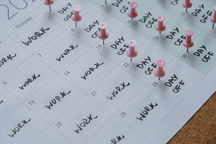 4-day workweek printed calendar with pink pins on the three days off