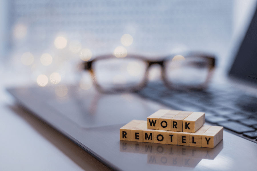 the words remote work written on wooden blocks placed on a laptop