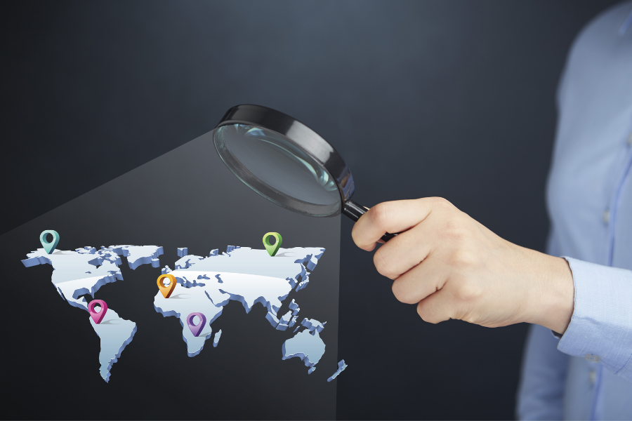 startup owner using magnifying glass to focus on a digital representation of global expansion plans