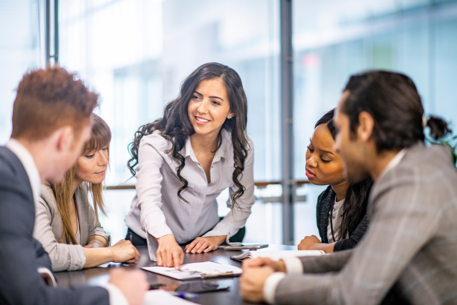 a female Indian employee discussing HR ideas with four colleagues