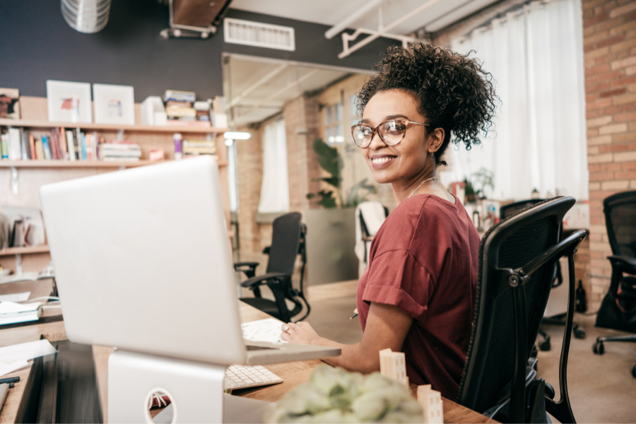 a female employee smiling in front of laptop