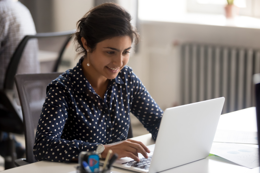 an Indian female employee reading about supplemental benefits on a laptop