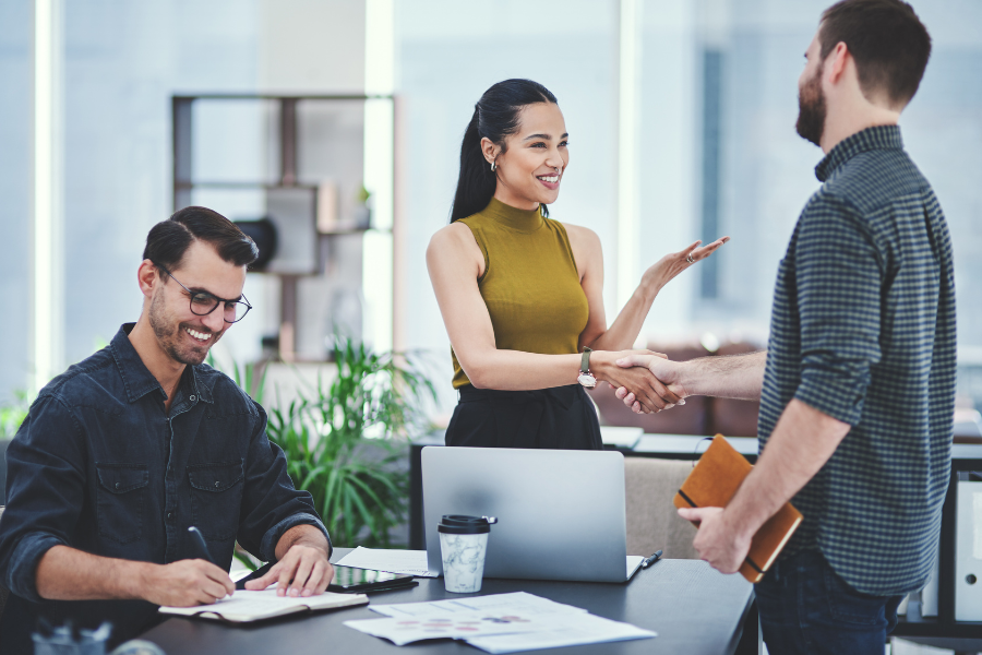 an HR manager shaking hands with a new employee