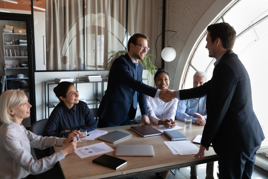 two businessmen shaking hands in a meeting room