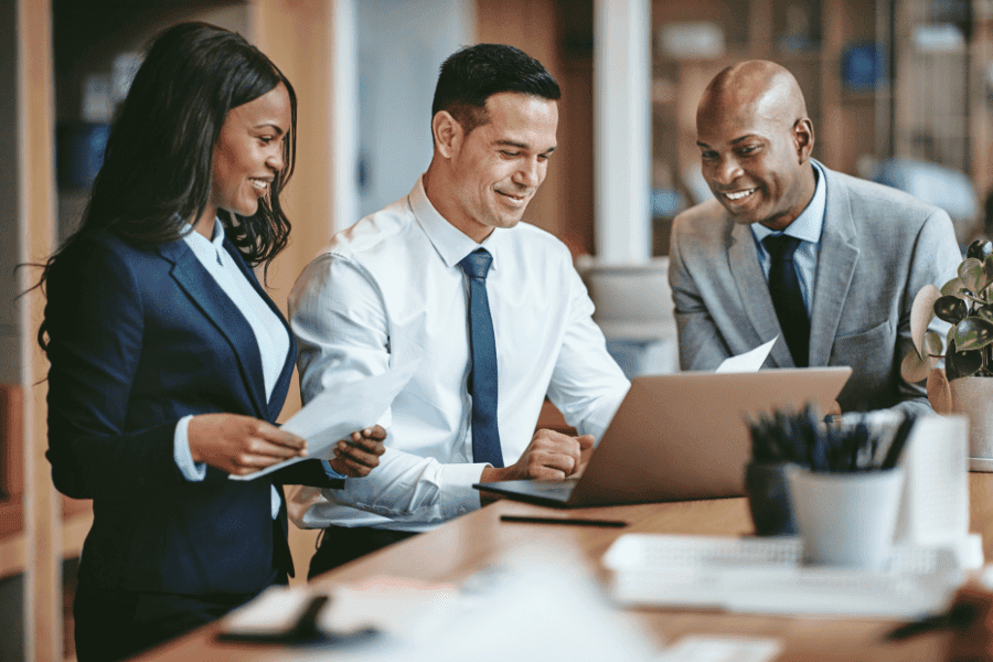 group of business people in Africa going over paperwork while working on laptop