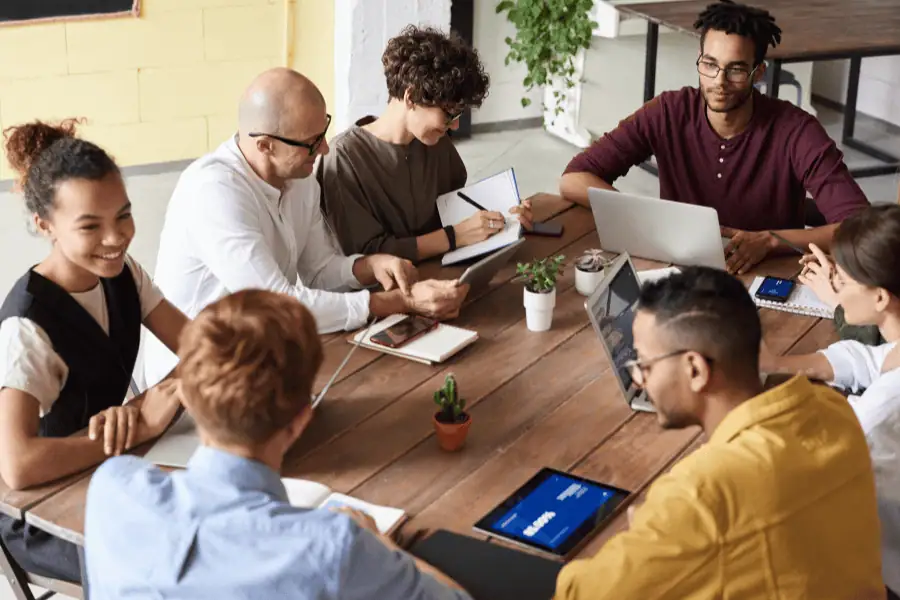 seven colleagues talking while sitting at a table