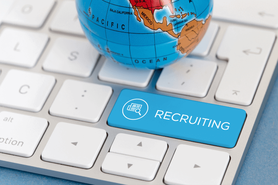 a globe placed on a keyboard with a recruiting key