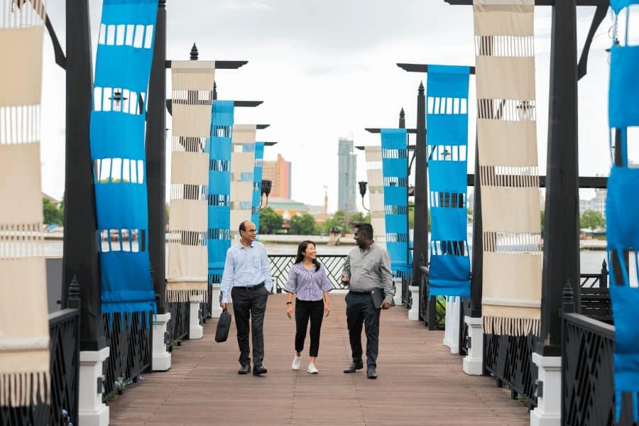Two men and one woman walking on a deck
