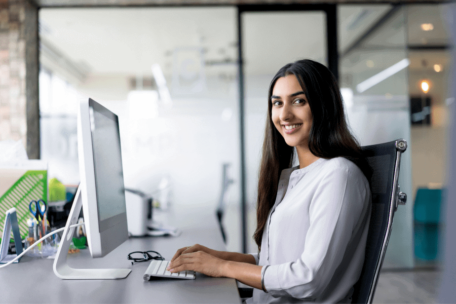 portrait of a happy Latin America employee working in front of a computer