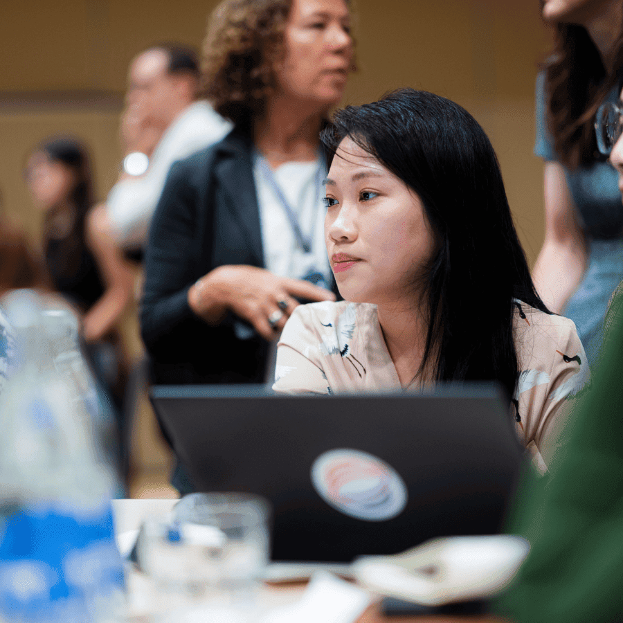 asian woman looking away from laptop