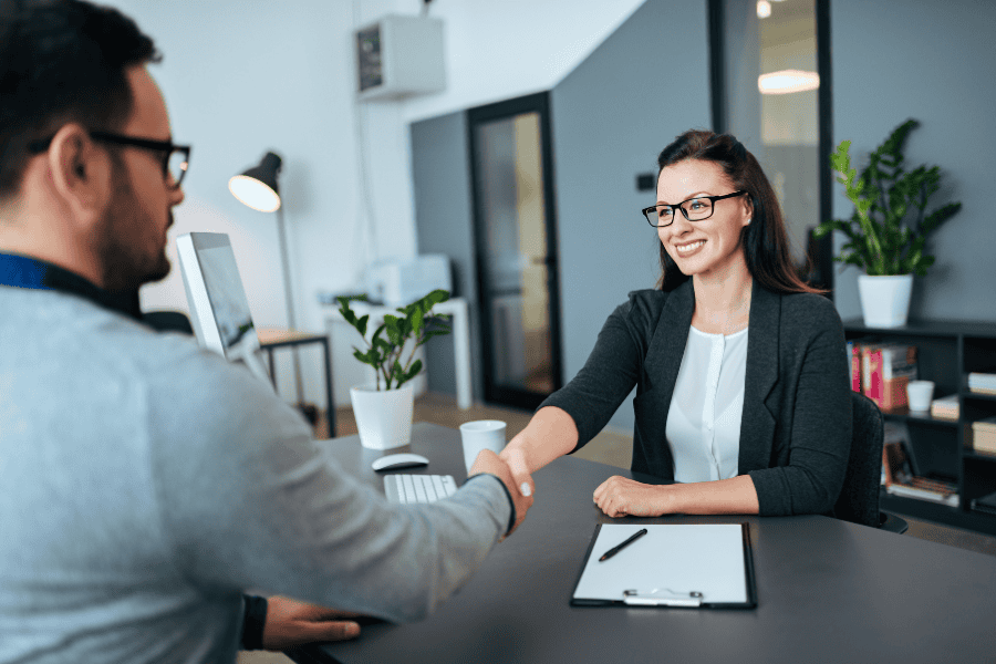 a visa officer shaking hands with an applicant