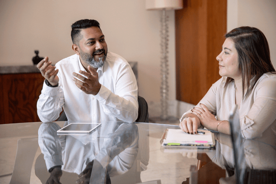 an African male employee and a Colombian female employee discussing work matters