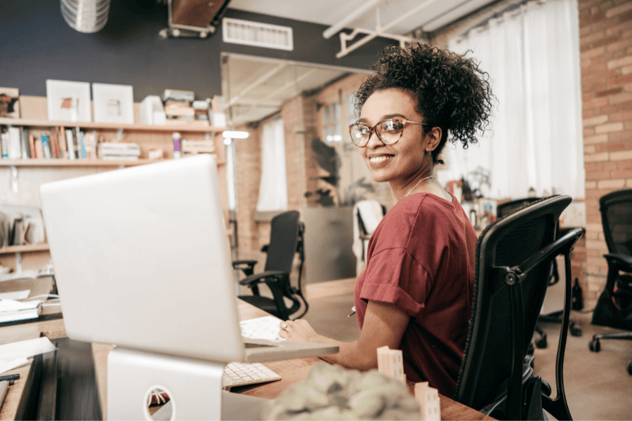 a female employee smiling in front of laptop