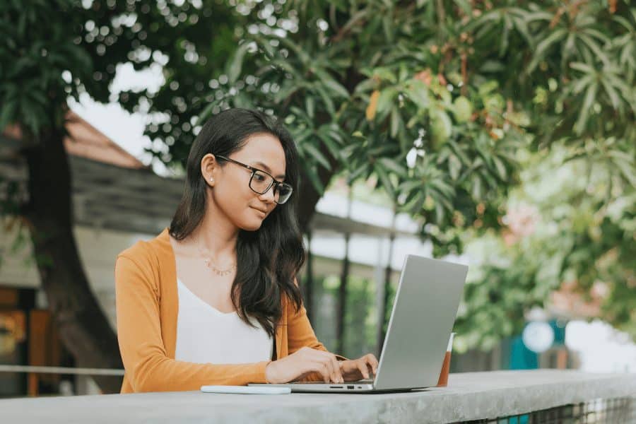 an asian woman working on her laptop