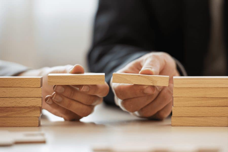 two people connecting two small blocks of wood