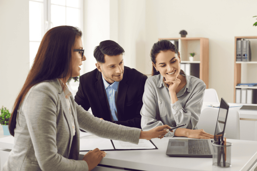 three colleagues discussing a payroll platform on a laptop