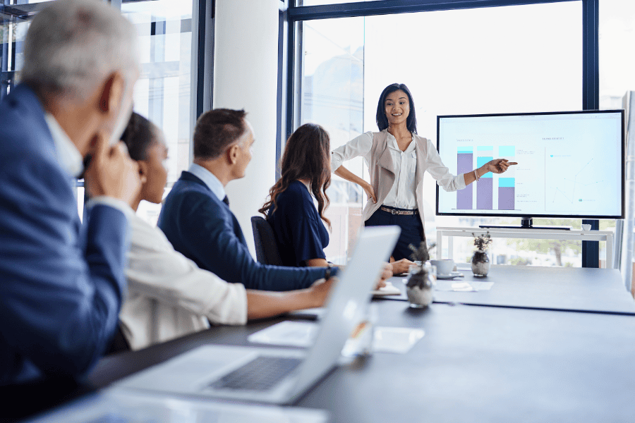 a businesswoman presenting to four colleagues