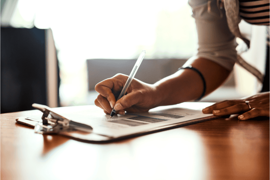 a hand of a business owner signing bank paperwork