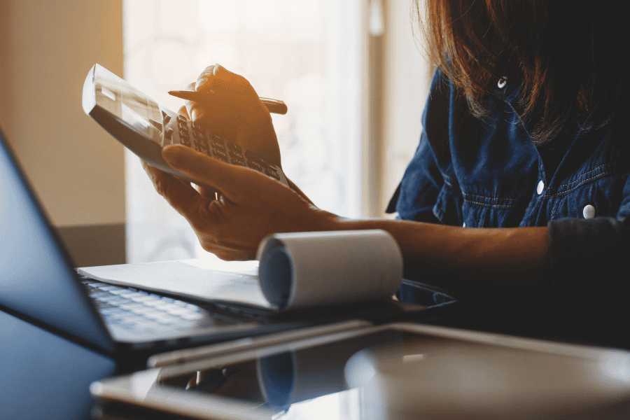 a female payroll staff using a calculator for payroll processing