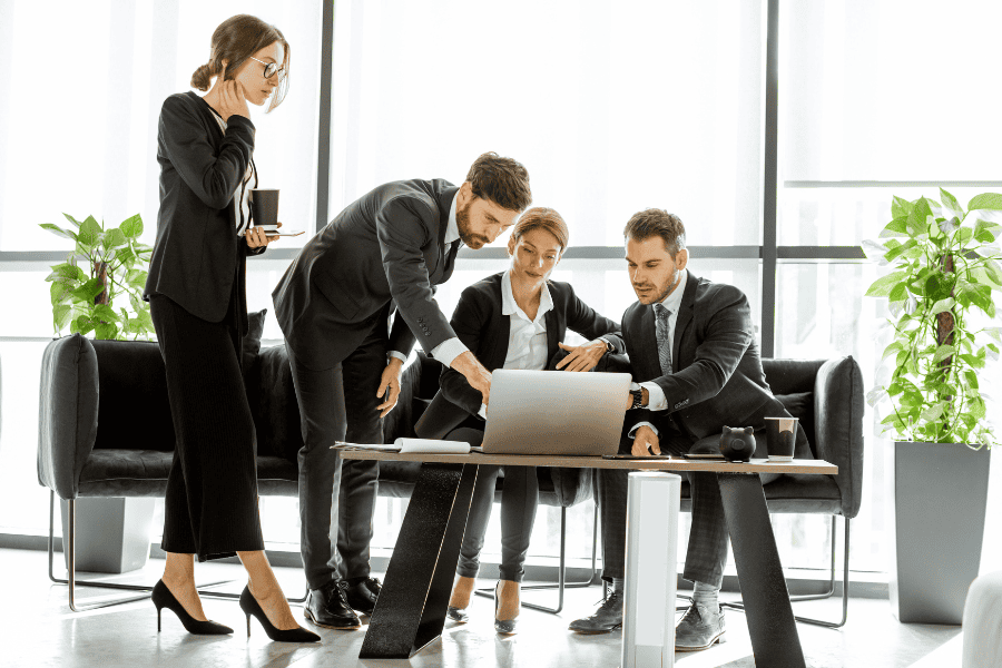 four colleagues looking at a laptop