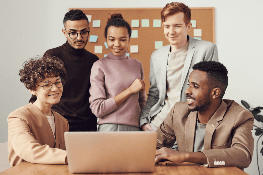 five colleagues discussing go-to-market strategy for Africa in front of a laptop