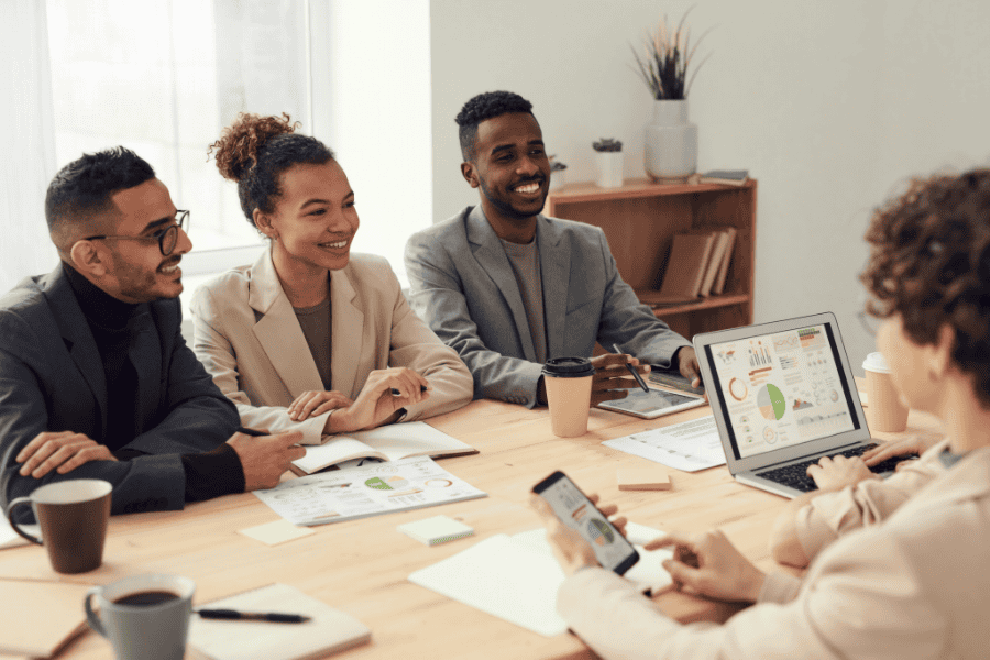 four colleagues smiling during a meeting