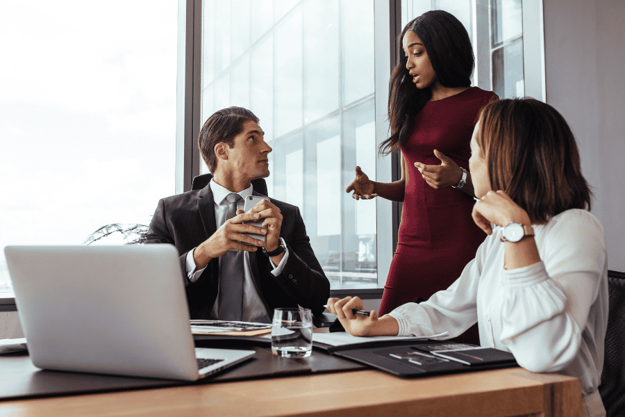 three colleagues discussing a mergers and acquisitions deal in an office