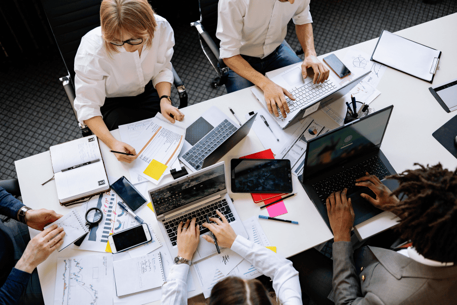 five colleagues working at a table