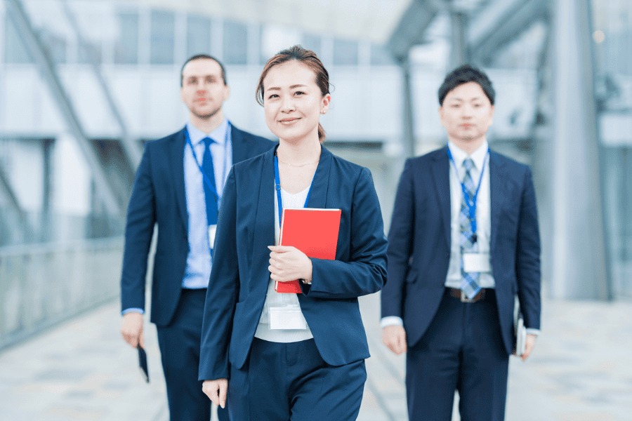 Three professionals in business attire walking toward the camera.