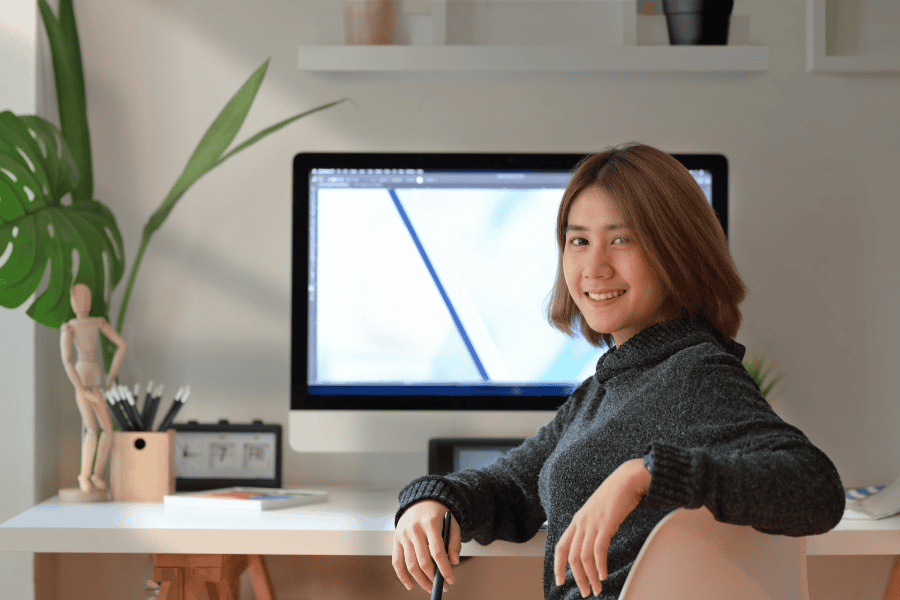 an independent contractor sitting in front of a monitor and looking at the camera