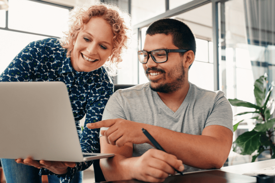 two colleagues discussing expansion strategy in front of a laptop