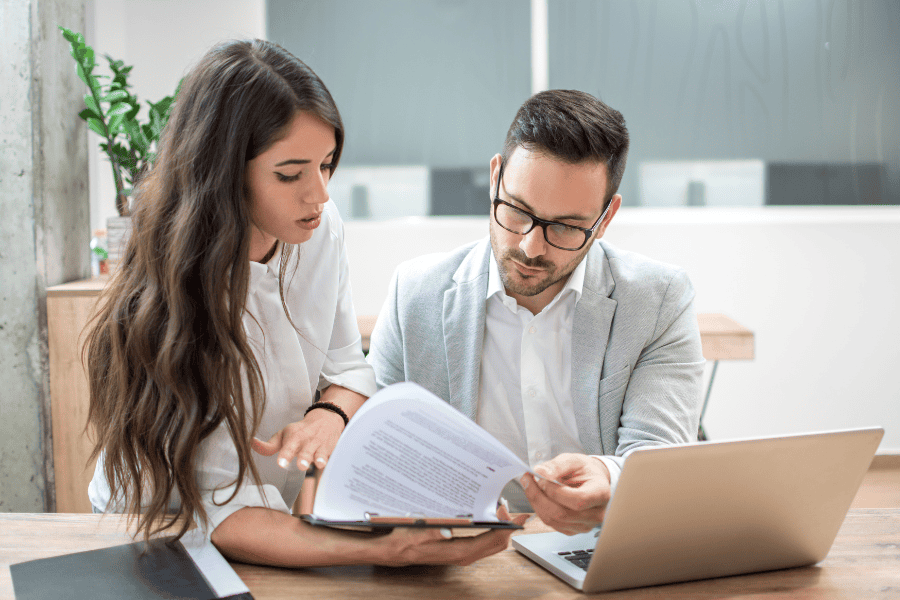 two colleagues reviewing a document at a table