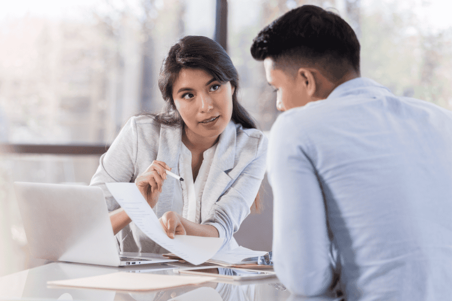 a professional woman explains US tax forms to a professional man