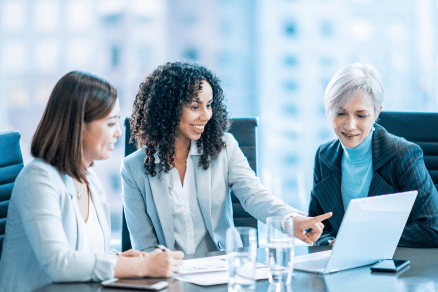 three female colleagues discussing compliance obligations