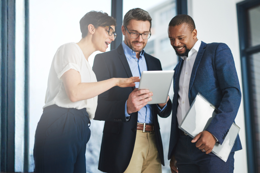 three business professionals looking at a tablet