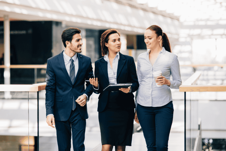 three colleagues discussing Canada entity setup while walking through a hallway
