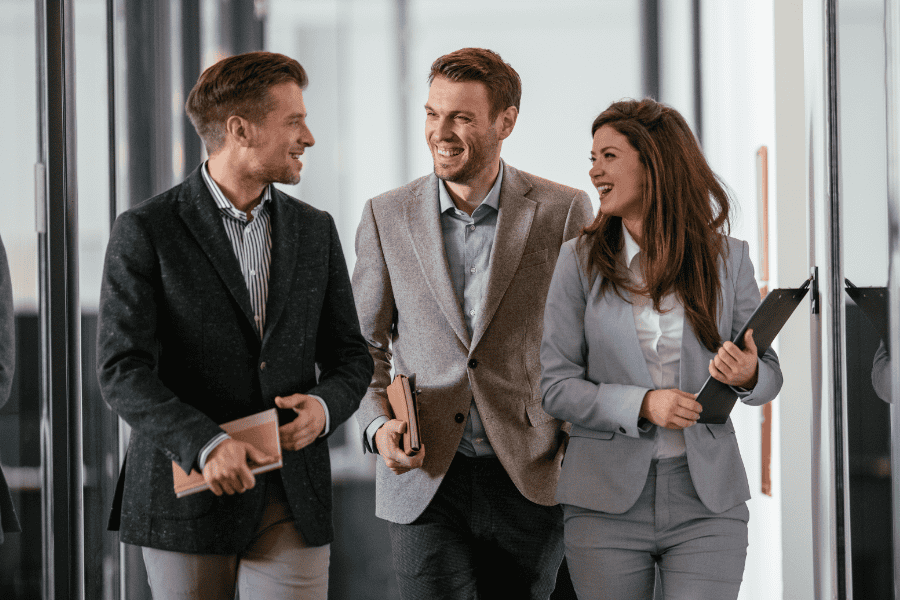 three colleagues discussing employee benefits while walking