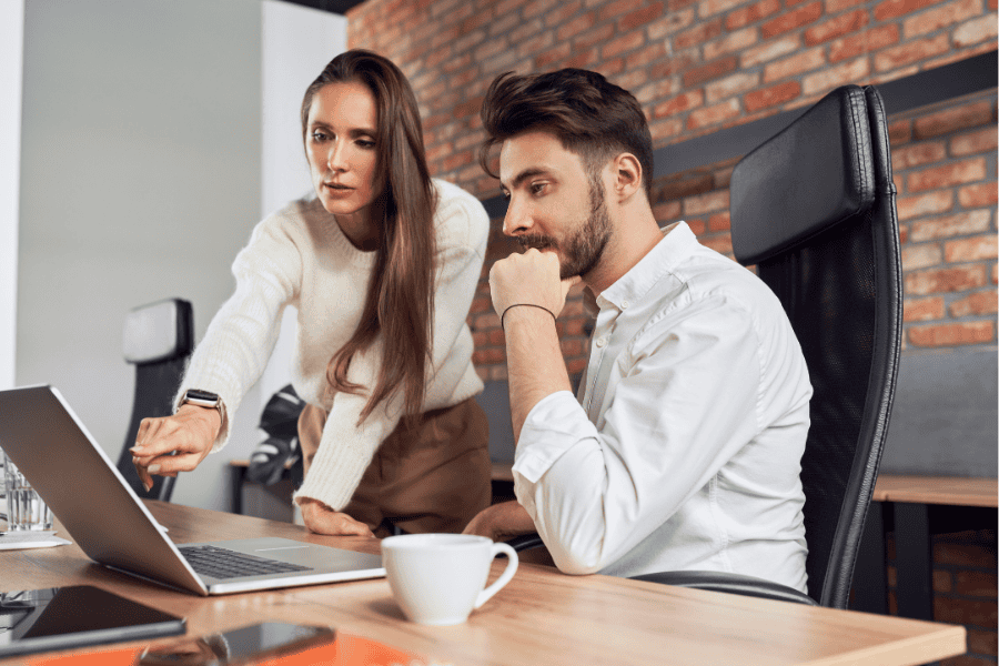 professional woman and man looking at a laptop together