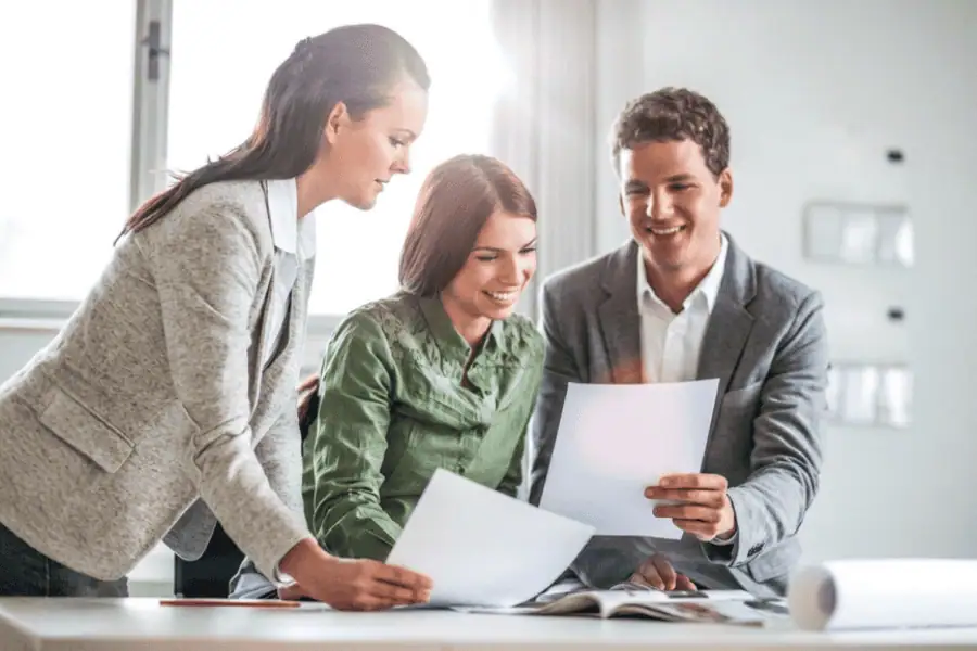 three colleagues looking at hiring paperworks