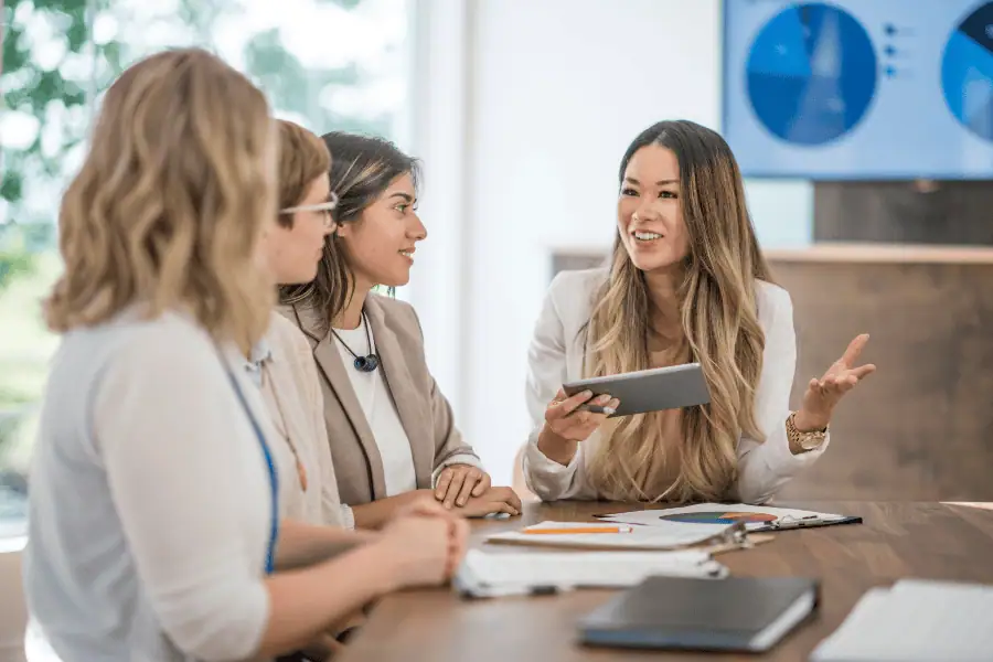 Women discussing business strategies in a professional office setting.