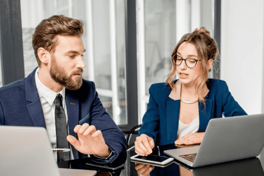 Two professionals in a business meeting discussing strategies at a modern office.