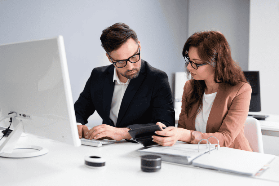 Two professionals reviewing financial documents in an office setting.