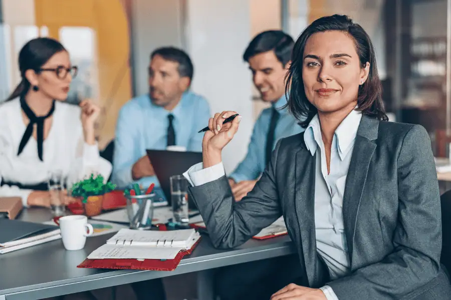 A professional woman at a meeting with colleagues.