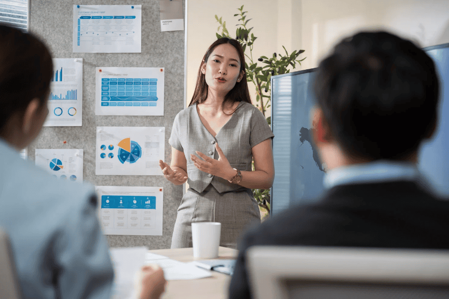Woman presenting data charts to team.